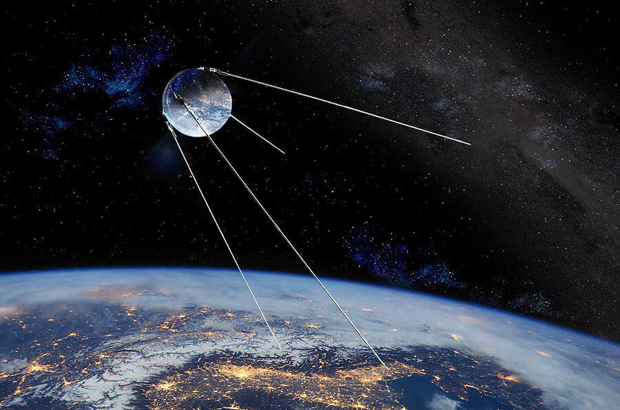 Sputnik na tle rozgwieżdżonego nieba. Na dole ziemia.