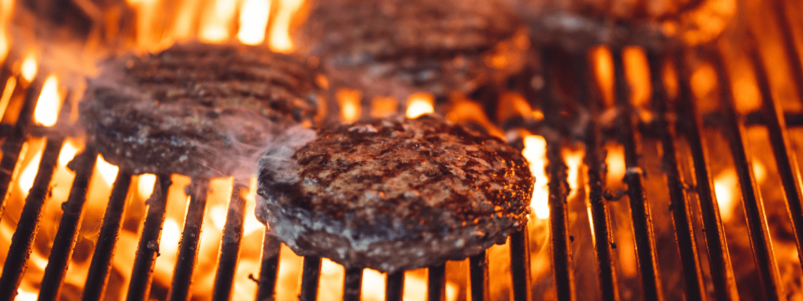 smażone burgery na grillu, dookoła płomienie