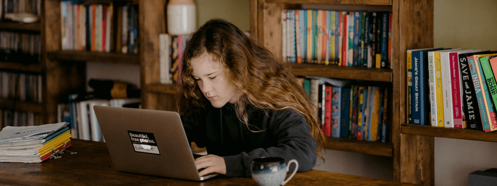 dziewczyna siedząca przy komputerze w bibliotece